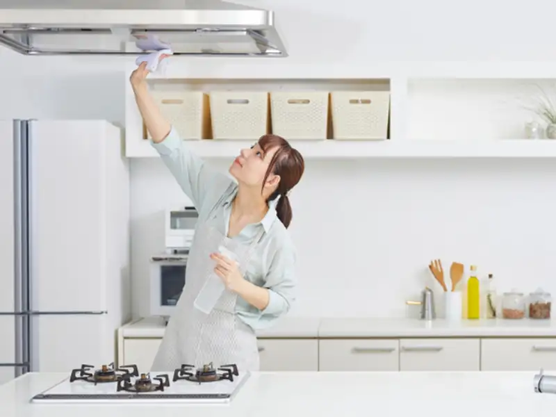 Cleaner degreasing kitchen cabinets and platform during kitchen cleaning in Indore